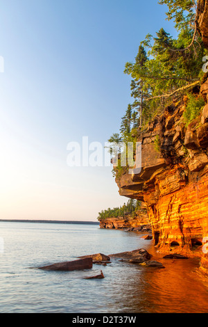 Layered sandstone cliffs and sea caves at sunrise on Devils Island in the Apostle Islands National Lakeshore, Wisconsin, USA Stock Photo