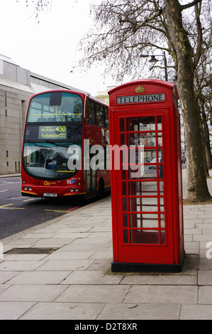 A typical K6 model London telephone box in front of a Volvo red London bus. Stock Photo