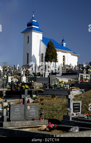 An old white chapel on a hill top over a cemetery in Slovakia Stock Photo