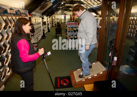 Outdoor walking  shoe boot shopping customer trying walking boots on artificial slope in 'Outdoor Sports shop in Ambleside Stock Photo