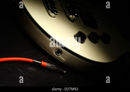 Detail on an electrical guitar and a red cord Stock Photo