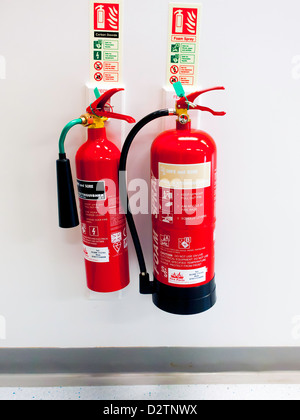 Carbon dioxide, and water fire extinguishers mounted on an office wall ...