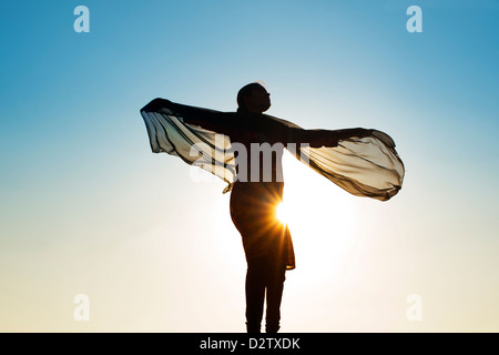Indian girl with a veil turning in the wind towards the sun. Silhouette. India Stock Photo