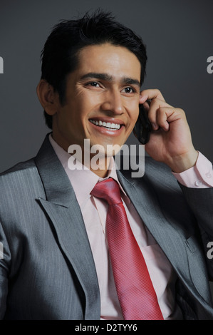 Businessman talking on a mobile phone and smiling Stock Photo