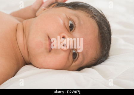 Close-up of a baby lying on the bed Stock Photo