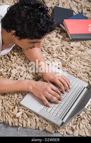 Man using a laptop on the floor Stock Photo
