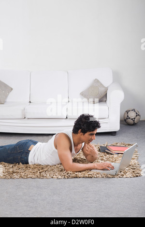 Man using a laptop on the floor Stock Photo