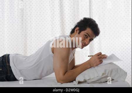 Man doing paperwork on the bed Stock Photo