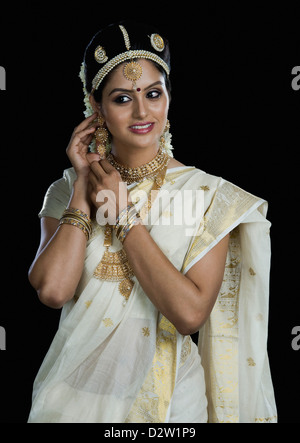 Indian woman in traditional clothing adjusting her earrings Stock Photo