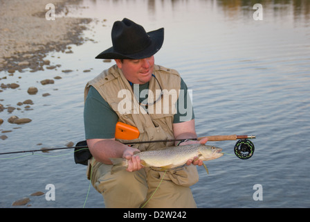 Chuck House holds a large Red Deer River Brown trout caught catch and release fly fishing on the Red Deer River, Alberta,Canada. Stock Photo