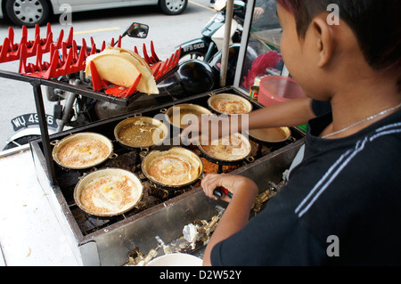 hawker making Apam balik (turnover pancake) Malaysian pancake with sugar, peanuts and creamy sweet corn fillings Stock Photo