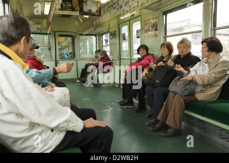 Senior passengers inside suburban commuter train, Kyoto, Japan Stock Photo