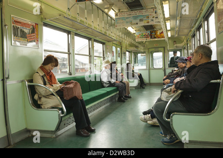 Passengers inside suburban commuter train, Kyoto, Japan Stock Photo