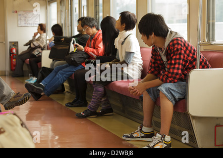 Passengers inside suburban commuter train, Kyoto, Japan Stock Photo