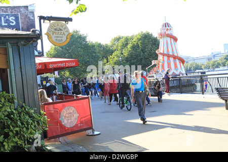 Tourists walking on the Riverside Walk, on the South Bank, by Gabriel's Wharf, on a warm, summer's afternoon, in London, UK Stock Photo