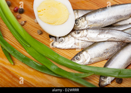 salted anchovies, egg, and spring onion on wooden background Stock Photo