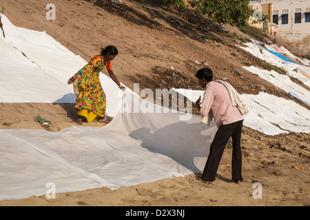 White sheets being laid out to dry on a ghat, Varanasi, India Stock Photo