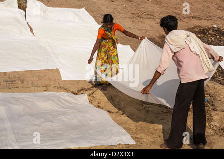 White sheets being laid out to dry on a ghat, Varanasi, India Stock Photo