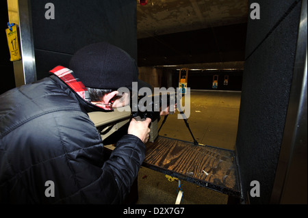 Target shooting with an AR-style target rifle at an indoor range Stock Photo