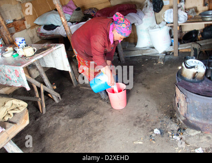 The woman at the camp prepares koumiss in the traditional way Stock Photo