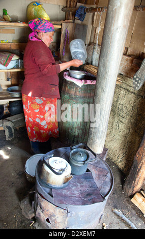 The woman at the camp prepares koumiss in the traditional way Stock Photo