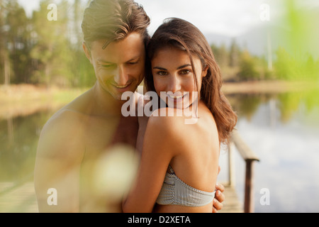 Portrait of smiling couple hugging at lakeside Stock Photo