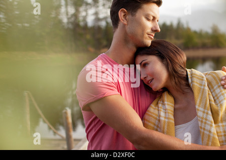 Serene couple hugging at lakeside Stock Photo