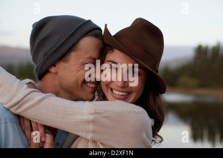Close up portrait of happy couple hugging at lakeside Stock Photo