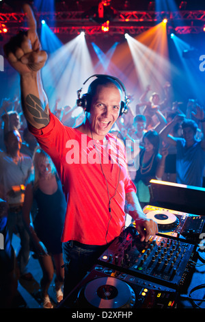Portrait of enthusiastic DJ at turntable in nightclub Stock Photo