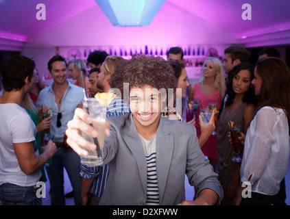 Portrait of smiling man holding cocktail at bar in nightclub Stock Photo