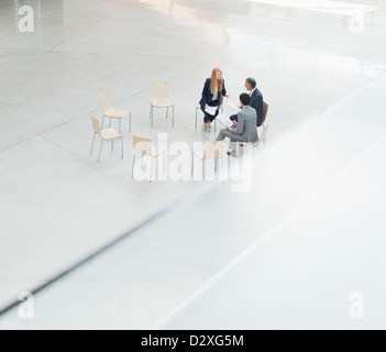 Business people meeting at circle of chairs in lobby Stock Photo