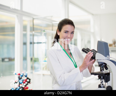 Portrait of confident scientist using microscope in laboratory Stock Photo