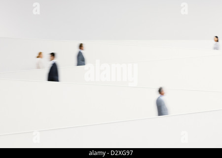 Blurred business people walking along modern staircase Stock Photo