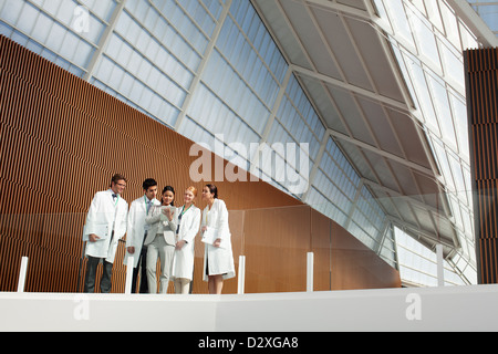 Doctors and businesswoman using digital tablet on modern balcony Stock Photo