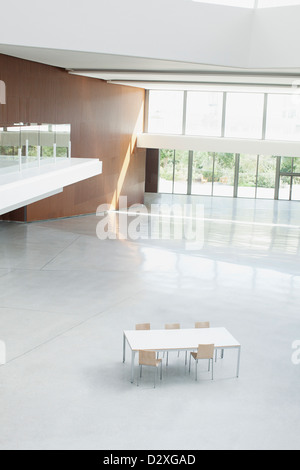 Table and chairs in empty office lobby Stock Photo
