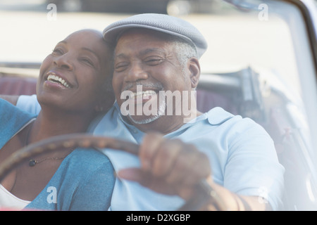 Couple driving in convertible together Stock Photo