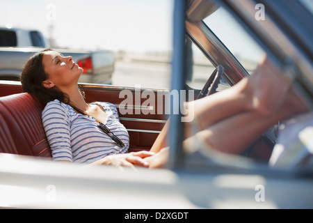 Smiling woman relaxing in convertible Stock Photo