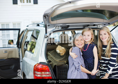 Three generations of women sitting in trunk Stock Photo