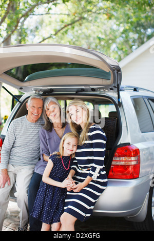 Family sitting in trunk of car Stock Photo