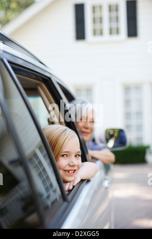 Older woman and granddaughter leaning out car windows Stock Photo