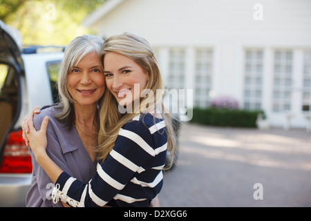 Mother and daughter hugging outdoors Stock Photo