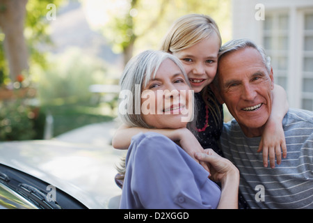 Older couple hugging granddaughter Stock Photo