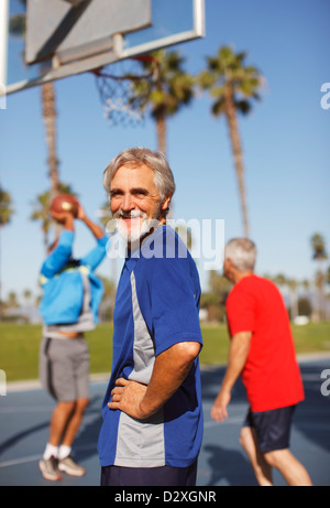 Older man playing basketball on court Stock Photo