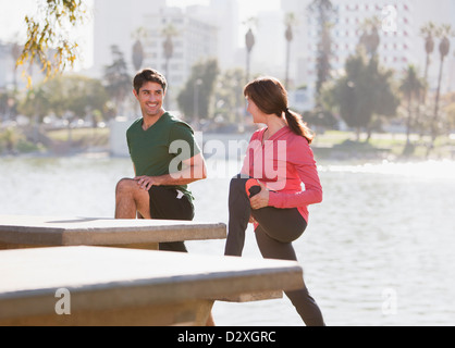 Couple stretching together in park Stock Photo