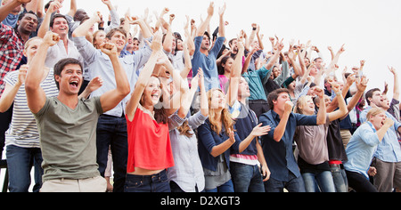 Cheering fans in crowd Stock Photo