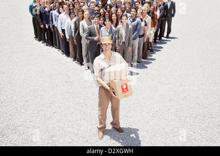 Portrait of smiling delivery woman with business people in background Stock Photo