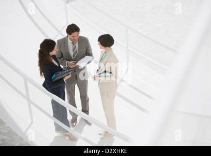 Business people reviewing paperwork on walkway Stock Photo