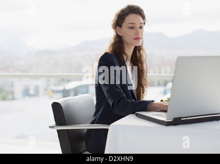 Businesswoman using laptop in office Stock Photo