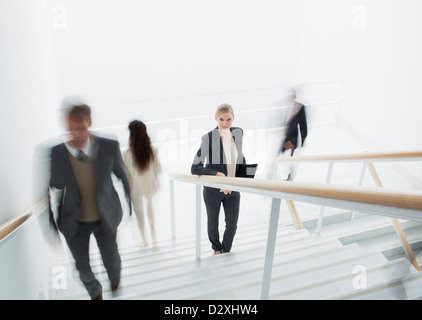 Business people rushing along stairs Stock Photo