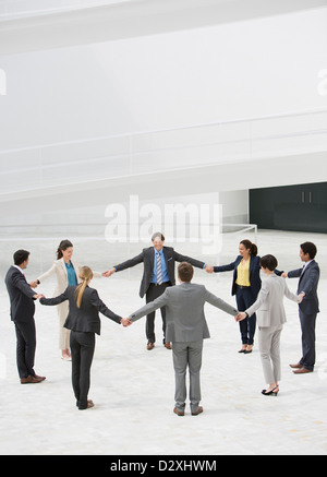 Business people holding hands in circle Stock Photo